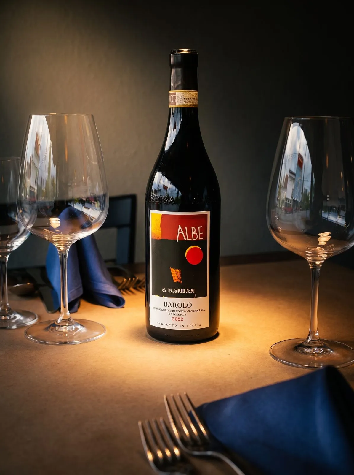 A bottle of Barolo in a pool of warm light.