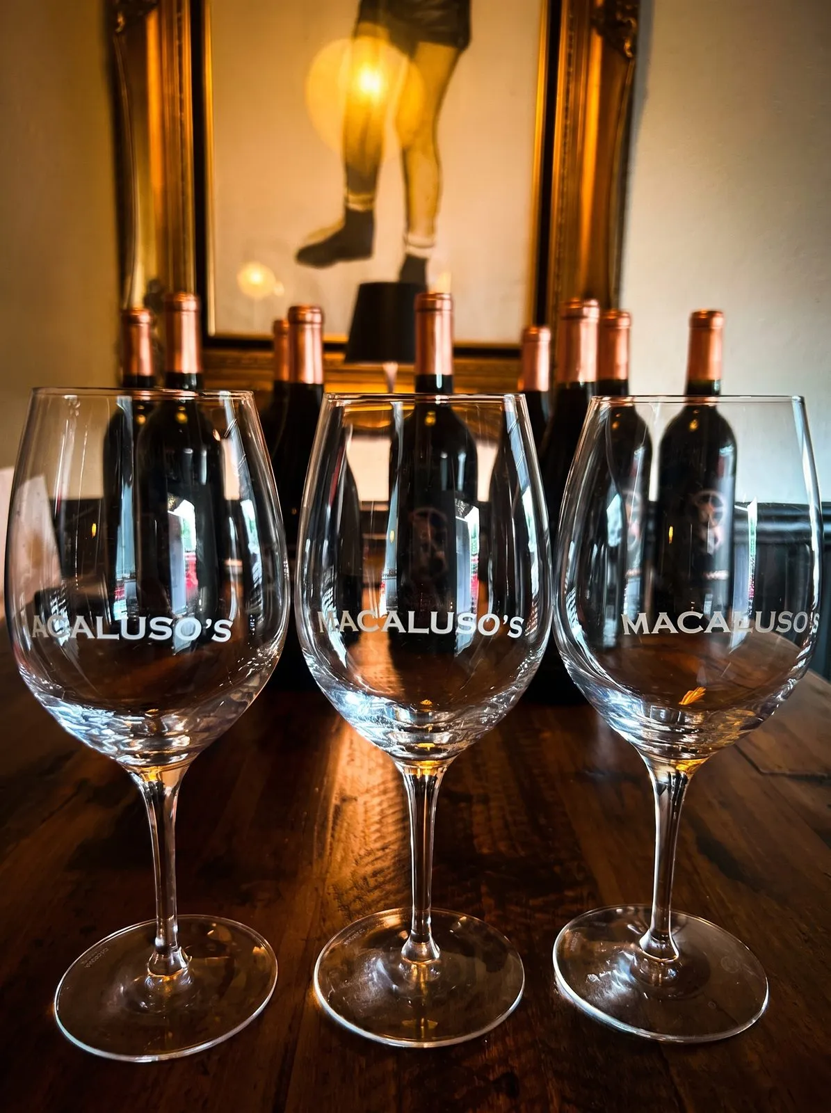 Wine glasses catching the evening light on a set table.